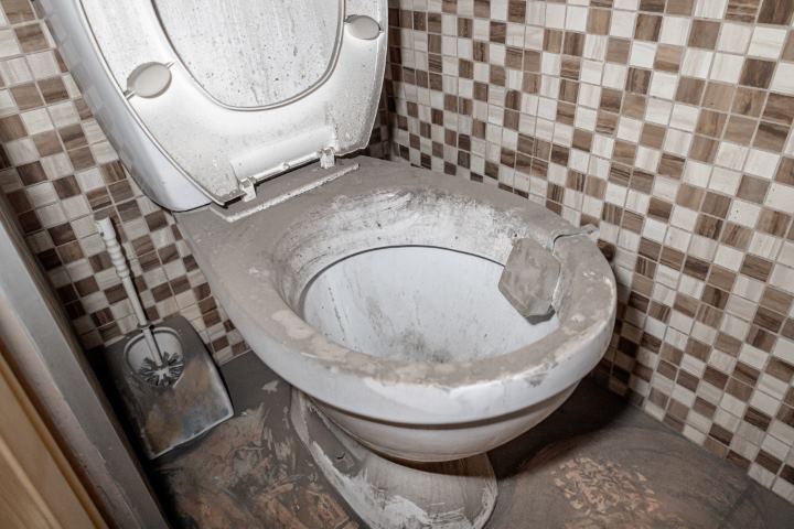 Very dirty toilet in dust and dirt, abandoned toilet, unsanitary conditions